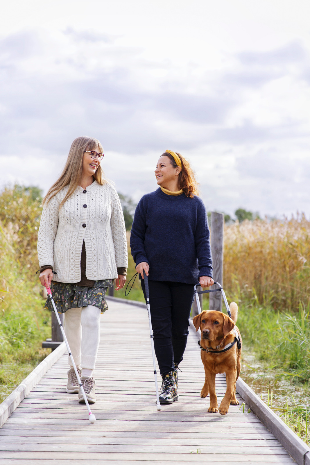 kolme henkilöä, kaksi naista ja mies juttelee kahvipöydässä.